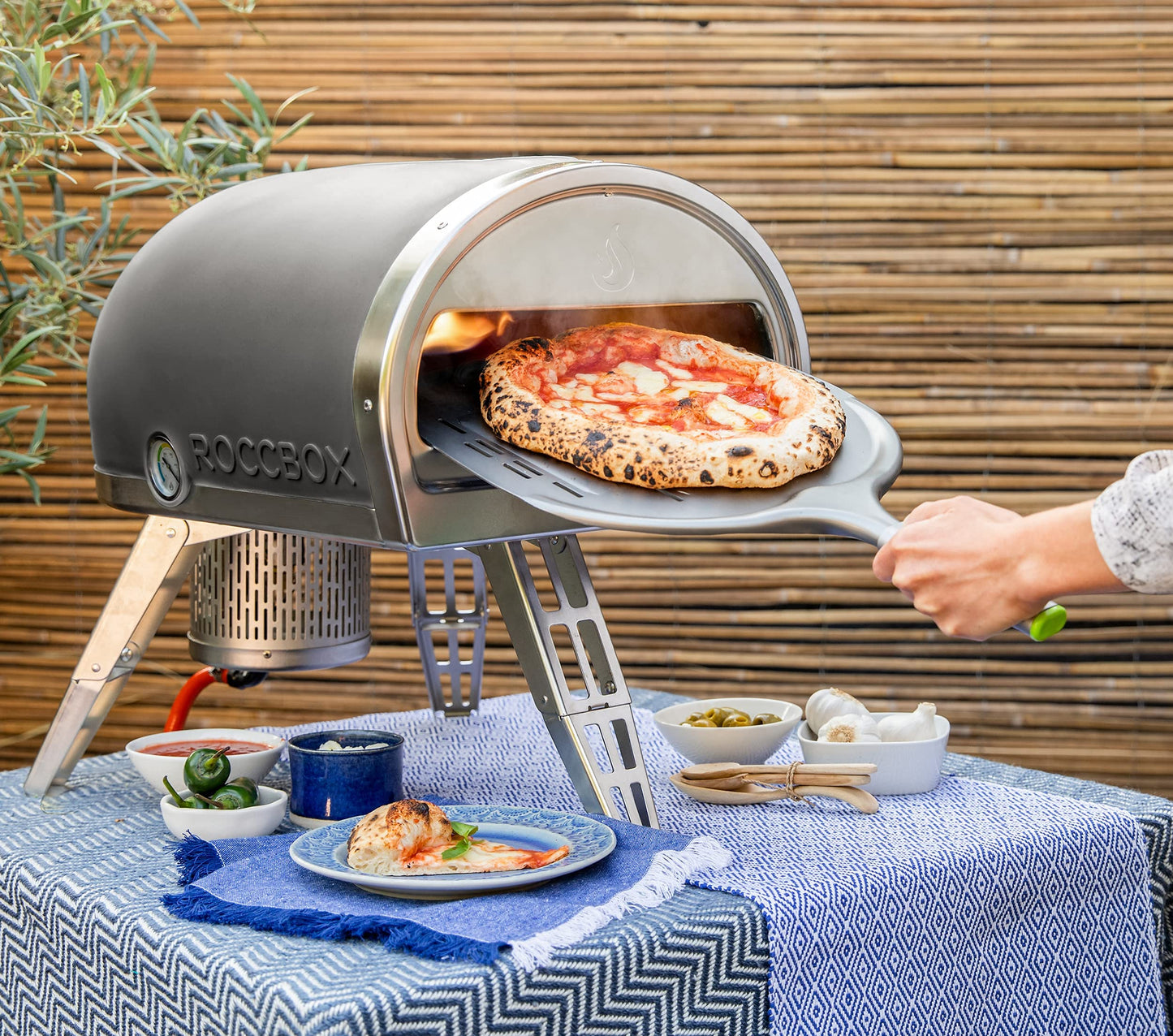 ROCCBOX Gozney Portable Outdoor Pizza Oven - Includes Professional Grade Pizza Peel, Built-In Thermometer and Safe Touch Silicone Jacket - Propane Gas Fired, With Rolling Wood Flame - Grey